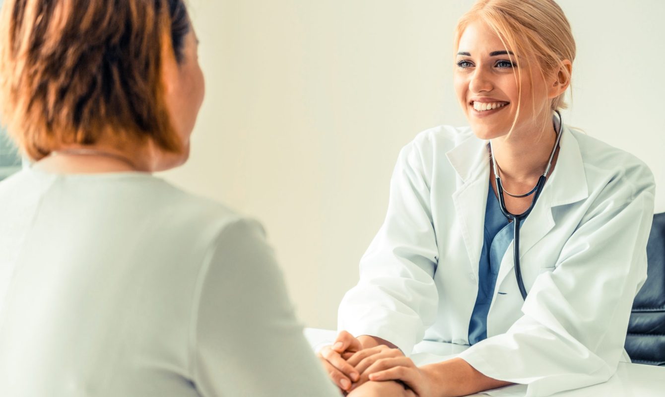 Woman Doctor and Female Patient in Hospital Office