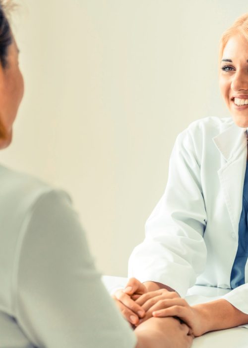 Woman Doctor and Female Patient in Hospital Office